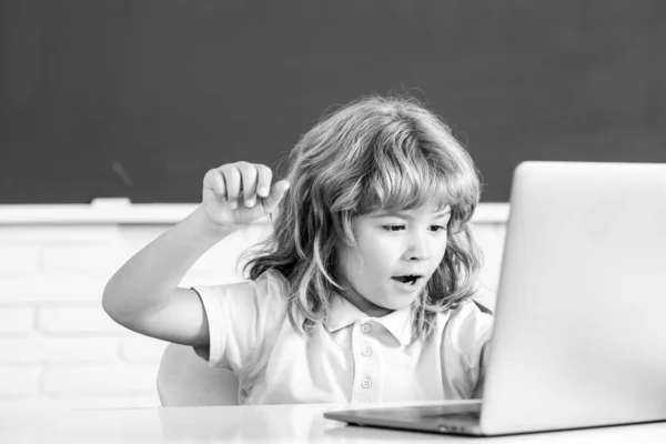Criança de escola usando laptop pc digital na classe. Retrato de aluno engraçado da programação do estudo da escola primária. Tecnologia de aprendizagem online, webinar de educação virtual. — Fotografia de Stock