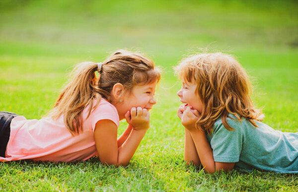 Kids couple in love. Two children on spring field. Adorable happy child outdoors on sunny day.