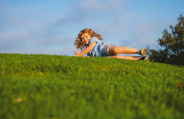 잔디 위로 떨어지는 소년. 공원에서 떨어지는 아이. — 스톡 사진