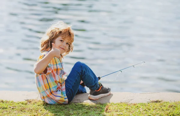 Feliz infância. Pesca infantil no lago. Jovem pescador. Rapaz com spinner no rio. Retrato de pesca menino animado. Rapaz no cais com vara. Conceito de pesca. — Fotografia de Stock