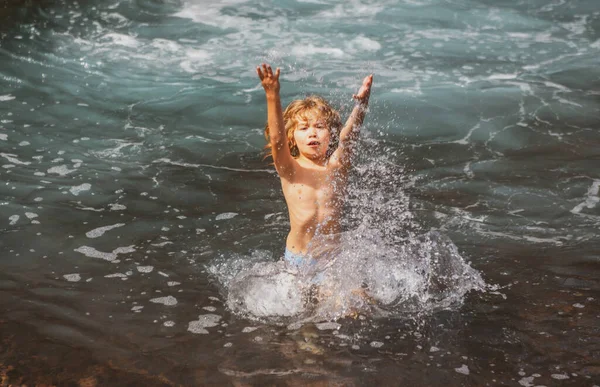 Joyeux enfant jouant dans la mer. Un gamin qui s'amuse à la plage. Vacances d'été et mode de vie actif concept. — Photo