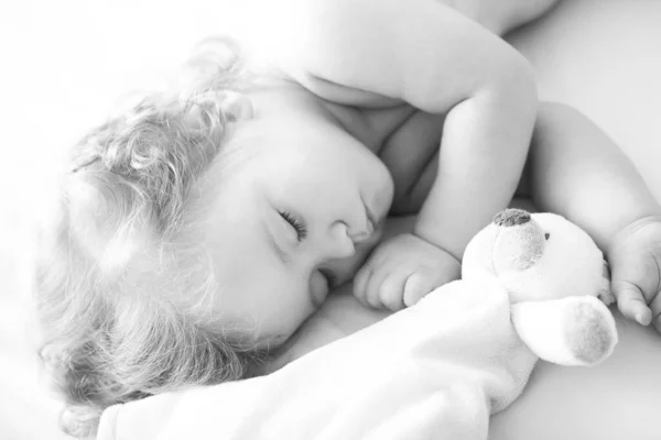 Симпатичный ребенок, спящий в постели дома с игрушкой, ребенок, спящий в кровати. — стоковое фото