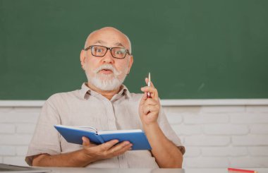 Üniversitede ya da üniversitede kıdemli öğretmen. Gemide yaşlı bir erkek öğretmen ve not defteri. Ders semineri yetenekleri. Yetişkin bir adam lisede okuyor..