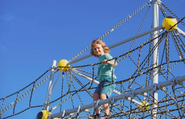 Παιδί παίζει στην εξωτερική παιδική χαρά σχοινί. — Φωτογραφία Αρχείου