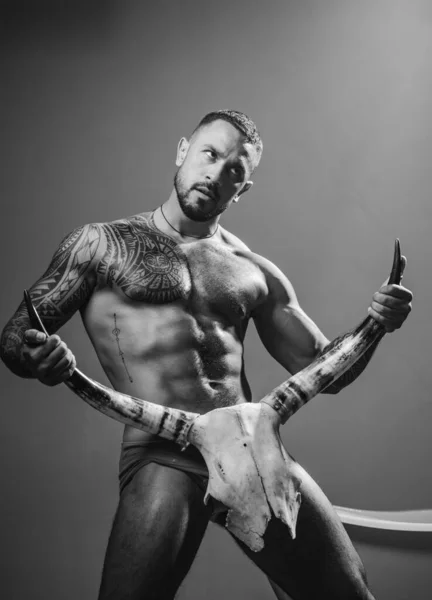Sexy muž s erotickým mužským, tělo šest balení držet býčí rohy. — Stock fotografie