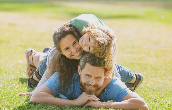 Glückliche Familie umarmt und umarmt auf Sommerspaziergang. Vater Mutter und Kind spazieren im Park und genießen die schöne Natur. Niedliches Familienporträt. — Stockfoto