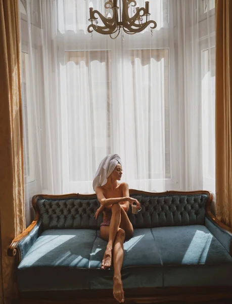 Красивые женщины в халатах и полотенцах в спальне после пробуждения. Сексуальные модели на кровати в квартире или гостиничном номере. Утренний отдых, прохлада. — стоковое фото
