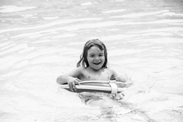 Festa estiva per bambini. Pool resort. Un ragazzo sorridente all'Aquapark. Bambino che nuota in acqua. Attività in piscina. Weekend attivo. — Foto Stock