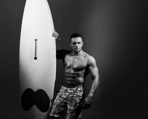 Hombre de tabla de surf con tabla de siervos. Surfista con tabla de surf. Sexy hombre mojado por todo el cuerpo sosteniendo el tablero de siervos con la mano derecha, mostrar ajuste y cuerpo muscular, posando modelo. — Foto de Stock