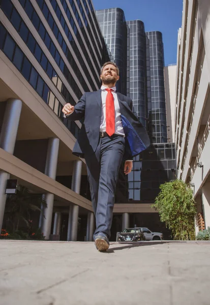 Sokakta yürüyen bir iş adamı. İş adamı modern ofis merkezine yakın yürür. İş başarısı, adım, kişisel kariyerini yükseltme ve kazanma.