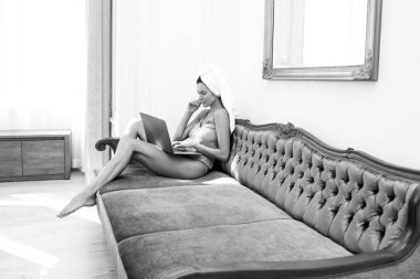 Evde dizüstü bilgisayar kullanan genç bir kadın. Sabahları yatakta uyuduktan sonra güzel bir kız. Yatağın üzerinde gevşemiş kadın manken gecenin bir yarısı uyanıyor..