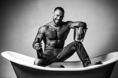 Seksi gülümseyen adam banyoda küvete oturur, erkekler şampanya ile tatil yapar. Noel 'i ya da doğum gününü kutlamak için. Özel seks partisi.