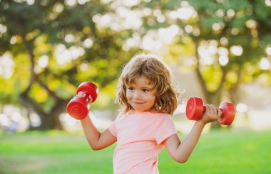 Çocuklar parkta spor yapıyor, spor yapıyor. Çocuklar sağlıklı bir yaşam tarzı. Güçlü kasları olan spor çocuğu..