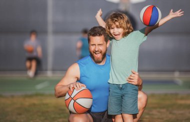 Babasıyla basketbol oynayan tatlı çocuk. Baba ve çocuk birlikte vakit geçiriyorlar. Baba ve oğul dışarıda oynuyorlar..