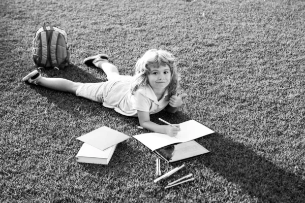 Söt härlig barnbok utanför. Grabben läste bok i parken. Förberedelser inför skoldagen och den internationella läskunnighetsdagen. Tillbaka till skolkonceptet. — Stockfoto