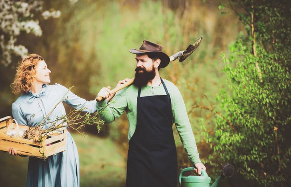 Bahçede çalışan bir çift çiftlik. Çiftlikte vakit geçirmeyi seviyorum. Çiftlik arazisinde gülümseyen çift. Çiftçiler bahar doğasını severler ve bitkileriyle ilgilenirler..
