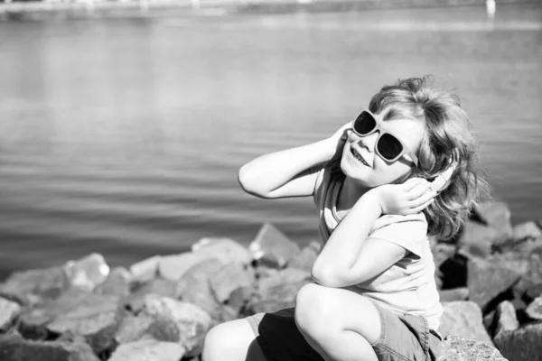 Música infantil. Muchacho de verano con auriculares. Niño en auriculares al aire libre. Concepto de escuchar música. —  Fotos de Stock