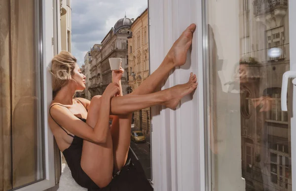 Sexy modelka si užívá ráno. Perfektní ženské nohy v obýváku doma. Luxusní krásná nahá dívka. Evropa dovolená. — Stock fotografie