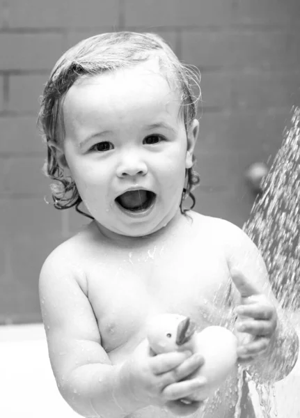 Kind onder de douche. Baby baadt in een bad met schuim en zeepbellen. — Stockfoto