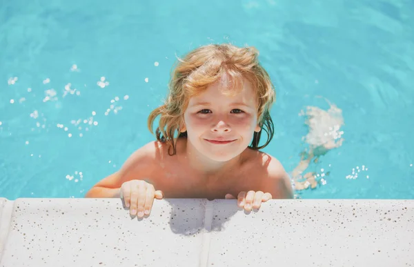 Симпатичный мальчик плавает в бассейне, летний водный фон с копировальным пространством. Забавное детское лицо. Ребенок играет на улице. Летние каникулы и здоровый образ жизни. — стоковое фото