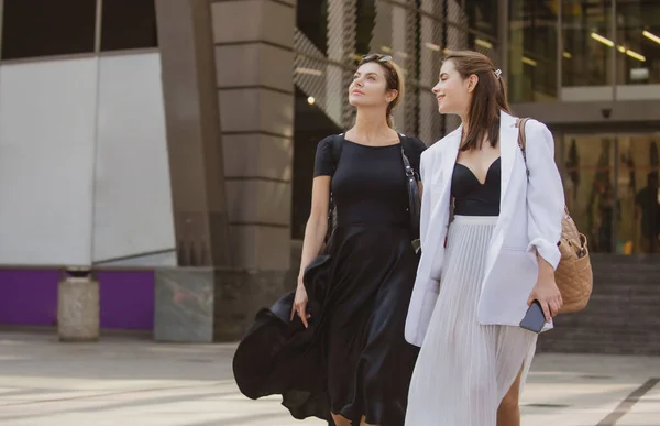 Loja de moda. Feliz sorridente namoradas mulheres andando na rua. Blogueiro da moda. — Fotografia de Stock