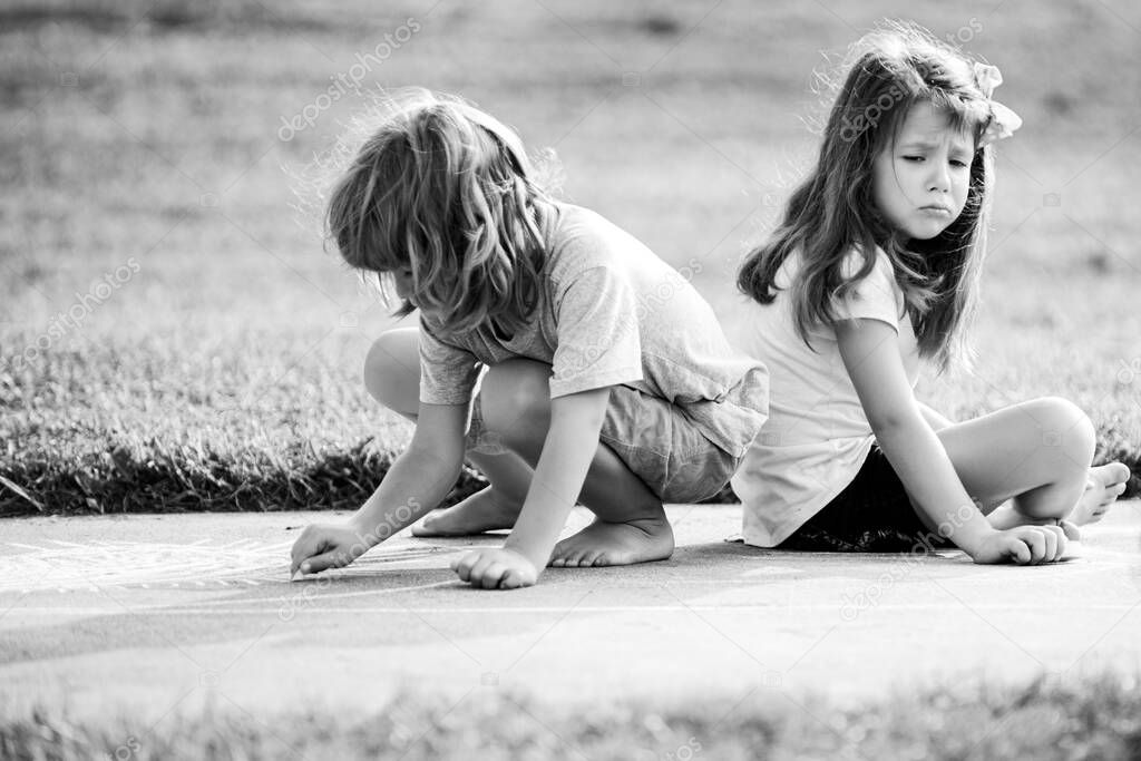 Kids relationships and adaptation. Couple of children playing outdoor. Boy and sad girl at park.