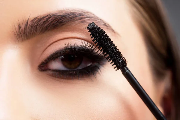 Eyebrow makeup. Beauty model shaping brows with brow pencil closeup. Beautiful woman contouring eyebrows. Macro close up of brows.