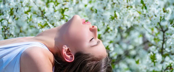 Concepto de cara femenina de primavera. Hermosa chica sobre fondo verde jardín de primavera. Diseño del resorte de la bandera, publicidad para el encabezado del sitio web. Fondo de flor de primavera. —  Fotos de Stock