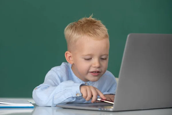 Niño de primaria que trabaja en clase de informática. Divertida rubia alumna en pizarra. — Foto de Stock