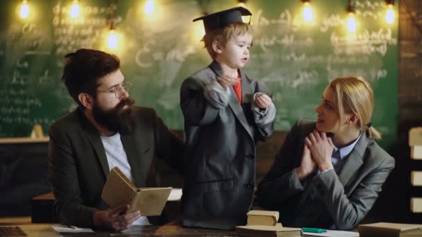 Educación en la primera infancia. Familia estudiando. Clases de gramática inglesa. El niño aprende gramática inglesa en clase. Padre enseña gramática inglesa a su hijo. Libros de gramática inglesa. — Vídeo de stock