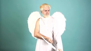 Sevgililer Günü 'nde ok atan komik, sevimli, yakışıklı adam. Aşk konsepti. Yakışıklı, çılgın, eğlenceli melek. Melek kanatlı sakallı melek Valentin. Sevgililer Günü. Komik mizah anlayışı.