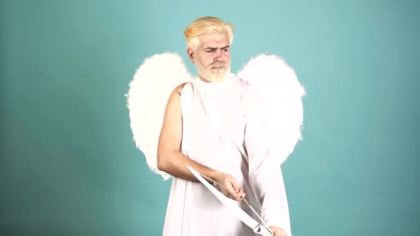 Funny cupid, handsome guy on valentine day with bow arrow shooting. Love concept. Handsome crazy fun angel. Bearded angel valentin man with angel wings. Valentines Day. Humor comical concept. — 图库视频影像
