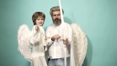 Valentin baba ve oğul, mavi arka planda ok ve yayla nişan alınmış kanatlı melekler. Mutlu aile ve sevgililer günü konsepti. Ebeveynlik, çocuklu ebeveyn, çocukluk..