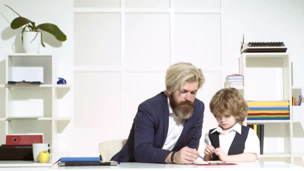 Отец бизнесмен с сыном рисуют на бумажках в офисе. У команды деловых людей встреча. Два партнера маленький детский бизнесмен и его наставник работают вместе проект. — стоковое видео