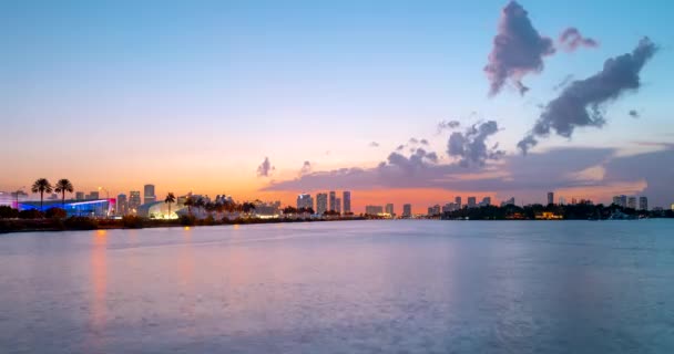 Miami panorama lapso de tempo. Céu noturno timelapse na cidade de Miami Beach. lapso de tempo de pôr do sol no céu cityscape e nuvens em movimento com reflexão ondulação de água. — Vídeo de Stock