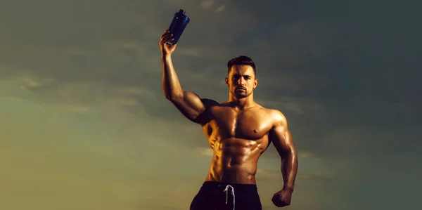Homem musculoso molhado com garrafa de água ou proteína. Modelos de bandeira com homem muscular, tronco muscular, seis abdominais bloco muscular. — Fotografia de Stock