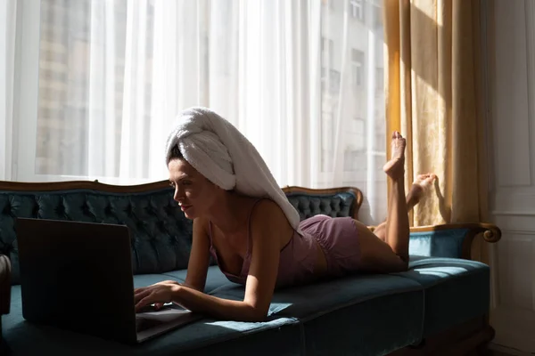노트북 컴퓨터를 사용하는 파자마의 아름다운 관능적 인 젊은 여성, 집 침실에서 아침 여가 시간을 즐긴다. — 스톡 사진