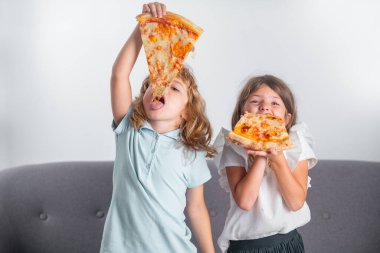 Çocuklar pizza yiyor. Tatlı komik çocuklar, tatlı pizza yiyen küçük kız ve oğlan..