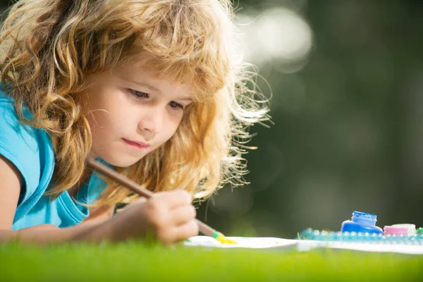 Künstlerkinder. Kinder malen mit Farbe und Pinsel im Park. — Stockfoto