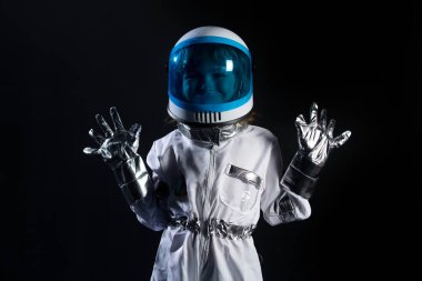 Küçük çocuk uzayda bir astronot kaskı takıp uçmak istiyor. Boşluğu kopyala.