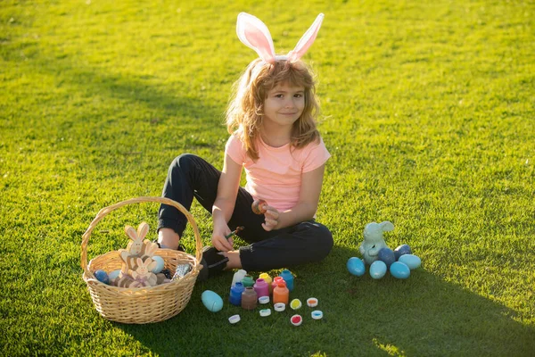 Kinderen vieren Pasen. Kind in konijnenkostuum met konijnenoren buiten. Schattig jongetje, paashaas kinderen lente outdoor. — Stockfoto