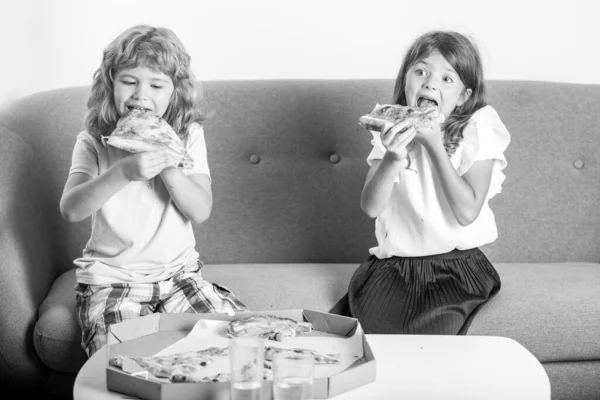 Funny cute children girl and boy eating tasty pizza. Hungry children eating pizza. — Stock Photo, Image