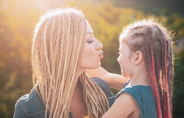 Mère heureuse et fille étreignant sur fond de lumière du soleil. — Photo