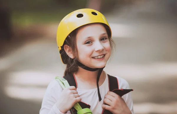 Petite fille escalade dans le parc d'activités d'aventure avec casque et équipement de sécurité. Petite fille qui grimpe sur un parc à cordes. Casque et équipement de sécurité . — Photo