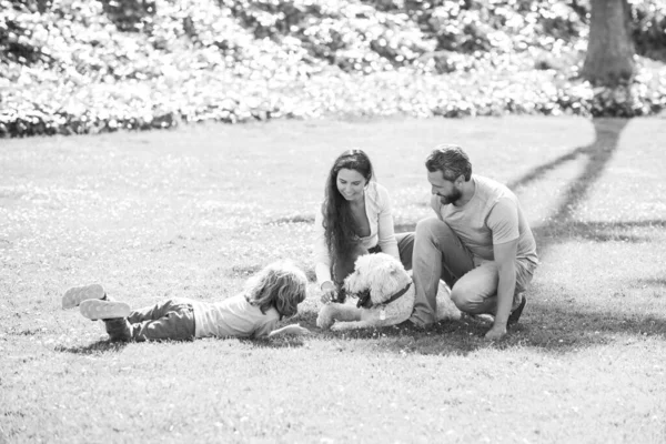 Jovem família feliz com cão de estimação passar o tempo juntos fora na natureza verde. — Fotografia de Stock