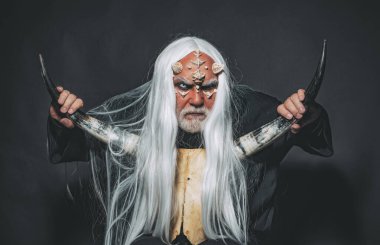 Ağaç ruhu ve fantezi konsepti. İblis suratlı harika bir büyücü adam. Beyaz mavi gözlü canavar. Korkunç cadılar bayramı adamı. Cehennemdeki Şeytan. Siyah zemin üzerinde Druid.