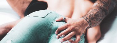 Handsome strong tattooed man touching his sexual partner girlfriend hot ass. Sexy desire and games. Sexy woman buttocks in blue jeans. Sexy couple in love foreplay and touch each other.