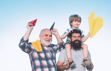 Dedemin oğlu ve torunu parkta eğleniyor. Babalar Günü - Büyükbaba, baba ve oğul kucaklaşıyor ve birlikte eğleniyorlar..