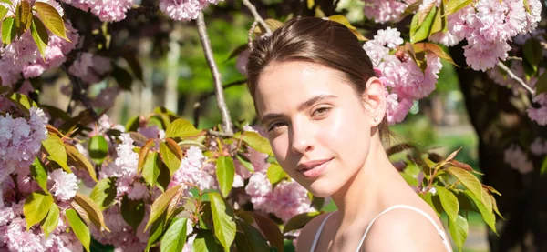 Chica en flor sakura de cerezo. Retrato al aire libre de hermosas chicas sensuales de moda posando cerca del árbol floreciente con flores rosadas. Diseño de primavera para banner o encabezado del sitio web. — Foto de Stock