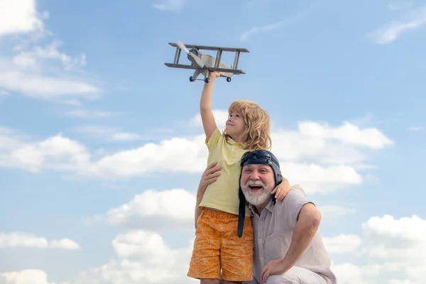 Grand-père et fils avec avion jetpack jouet contre ciel. Enfant pilote aviateur avec des rêves d'avion de voyager. — Photo